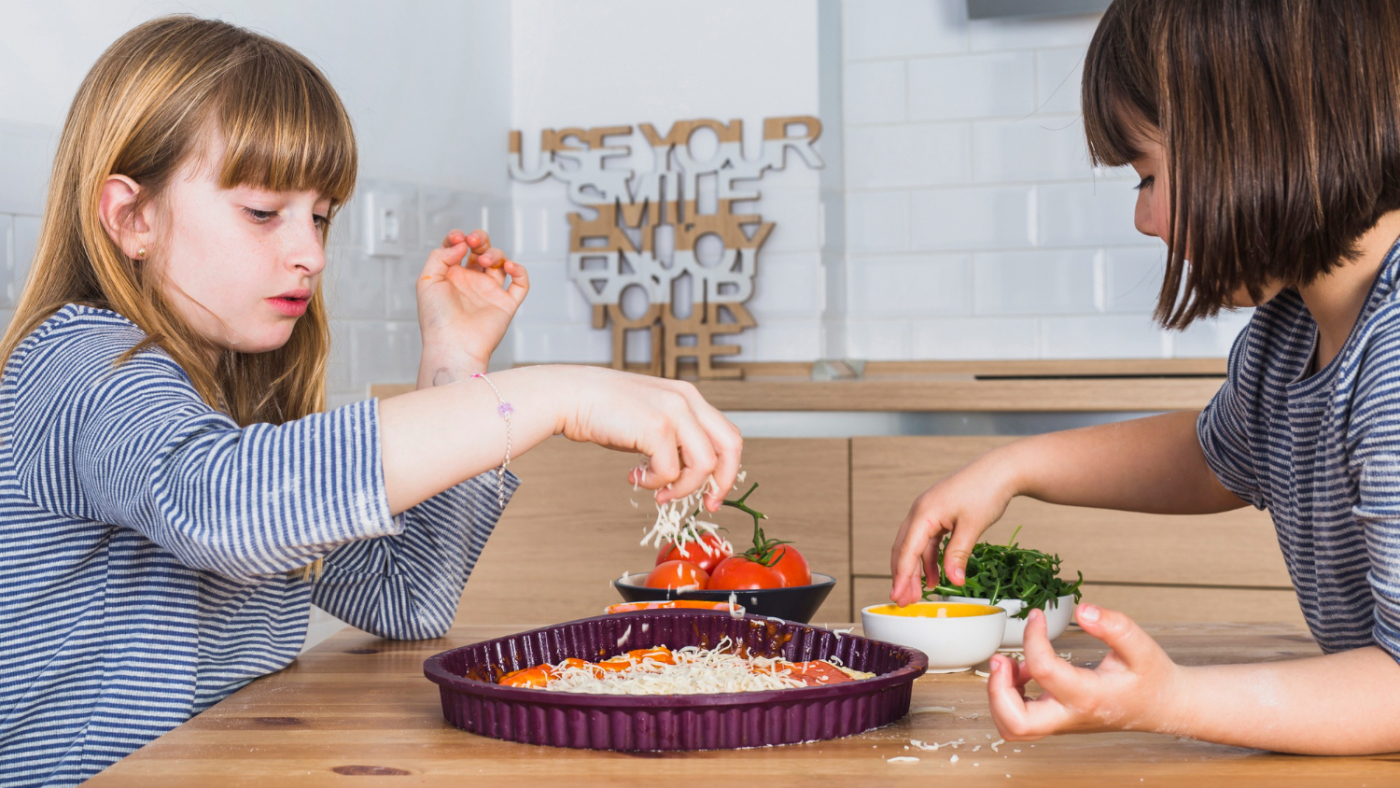 Kids adding toppings to pizza for Kid-Friendly Recipes fun