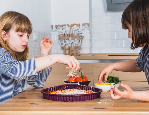 Kids adding toppings to pizza for Kid-Friendly Recipes fun