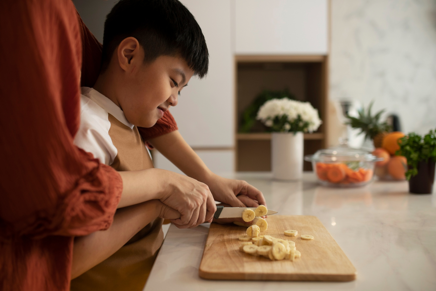 Child slicing bananas safely for Kid-Friendly Recipes prep